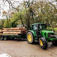 oak beams being delivered to site by tractor and trailer