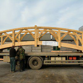 side view of oak garden bridge being loaded on to a truck