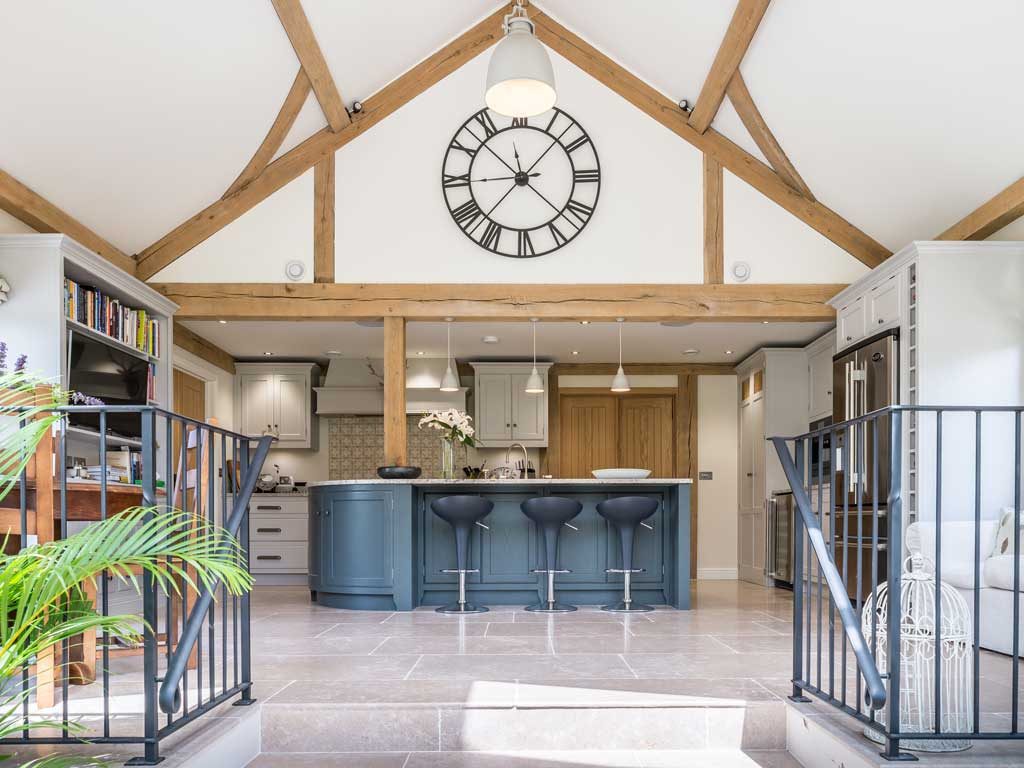 oak frame house blue kitchen with large clock in gable